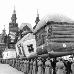 Red Army soldiers holding an inflatable Kolkhoz village in a Red Square parade. Little do they know that Captain Korolev is about to be involved in a nearby shoot-out that will send those balloon soaring skywards.